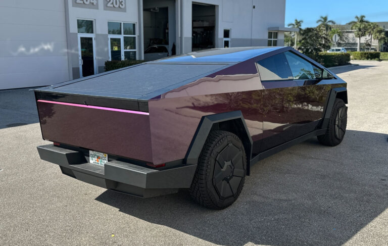 A sleek purple and black electric vehicle parked against a modern urban backdrop, showcasing its stylish design